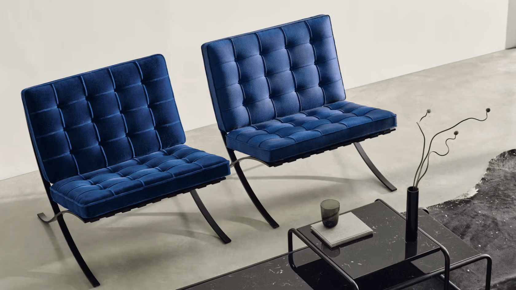 Blue modern lounge chairs with tufted upholstery, black coffee table, and minimalist contemporary interior.