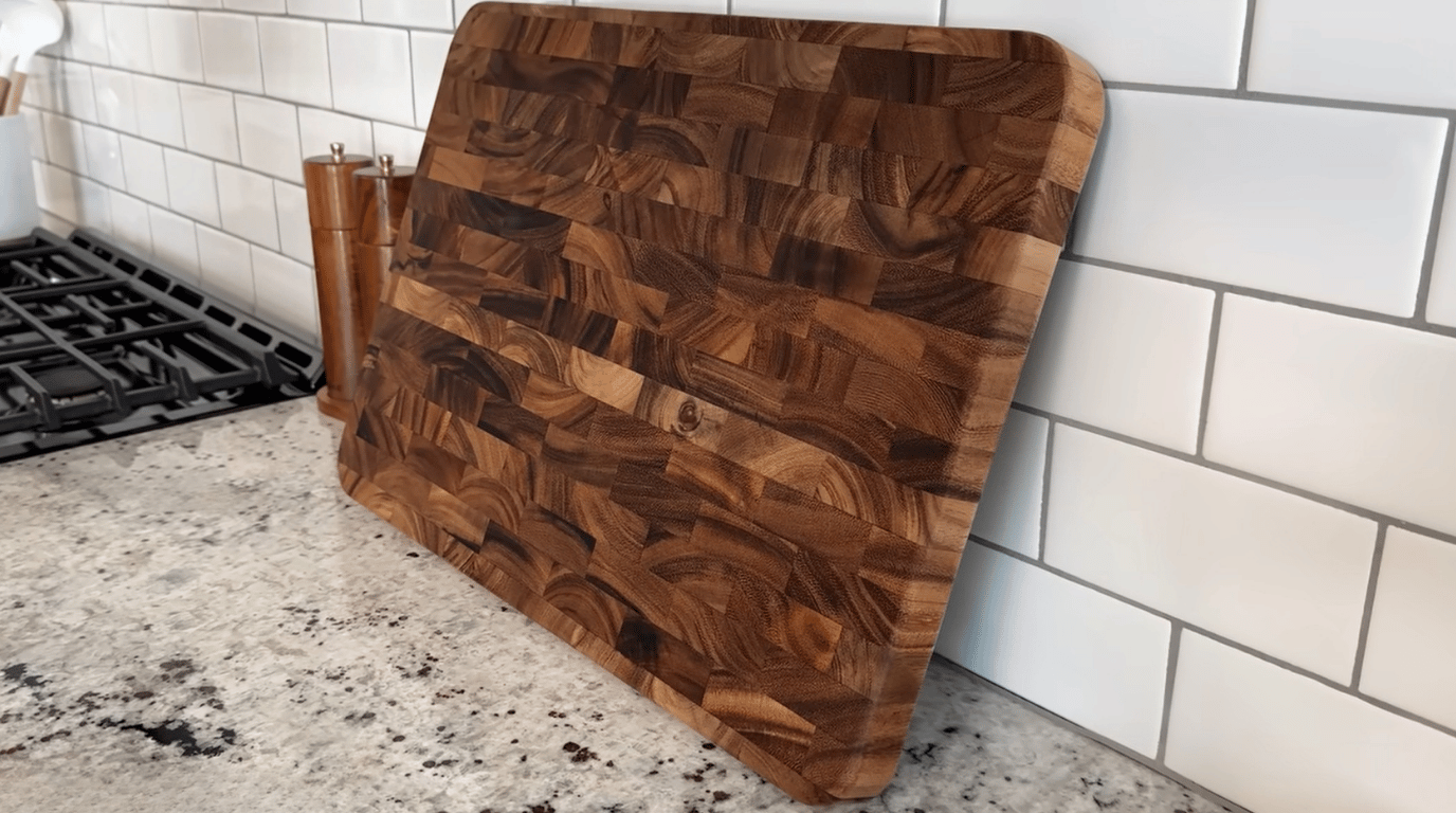clean wooden cutting board placed upright on a kitchen counter to dry after washing