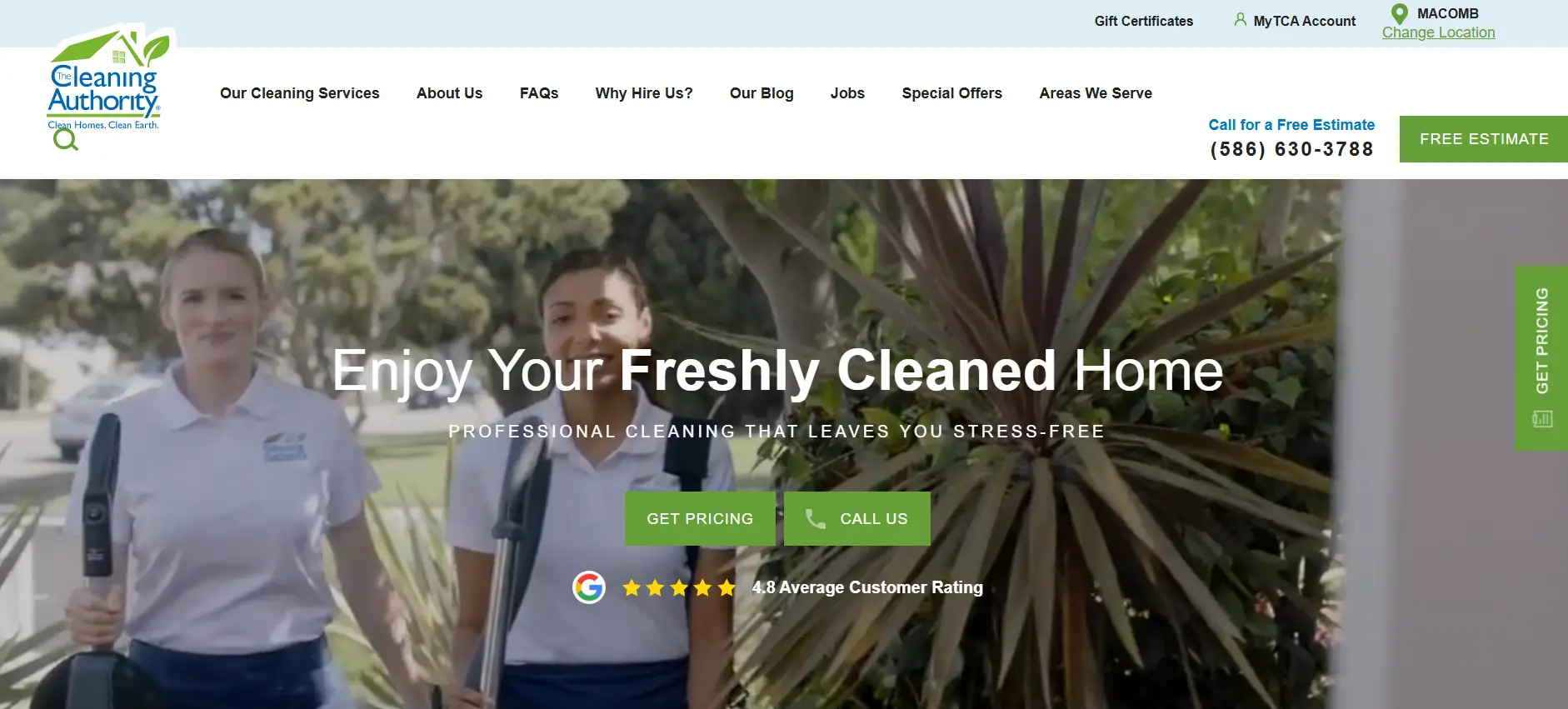 Two uniformed employees holding cleaning equipment outdoors with greenery in the background