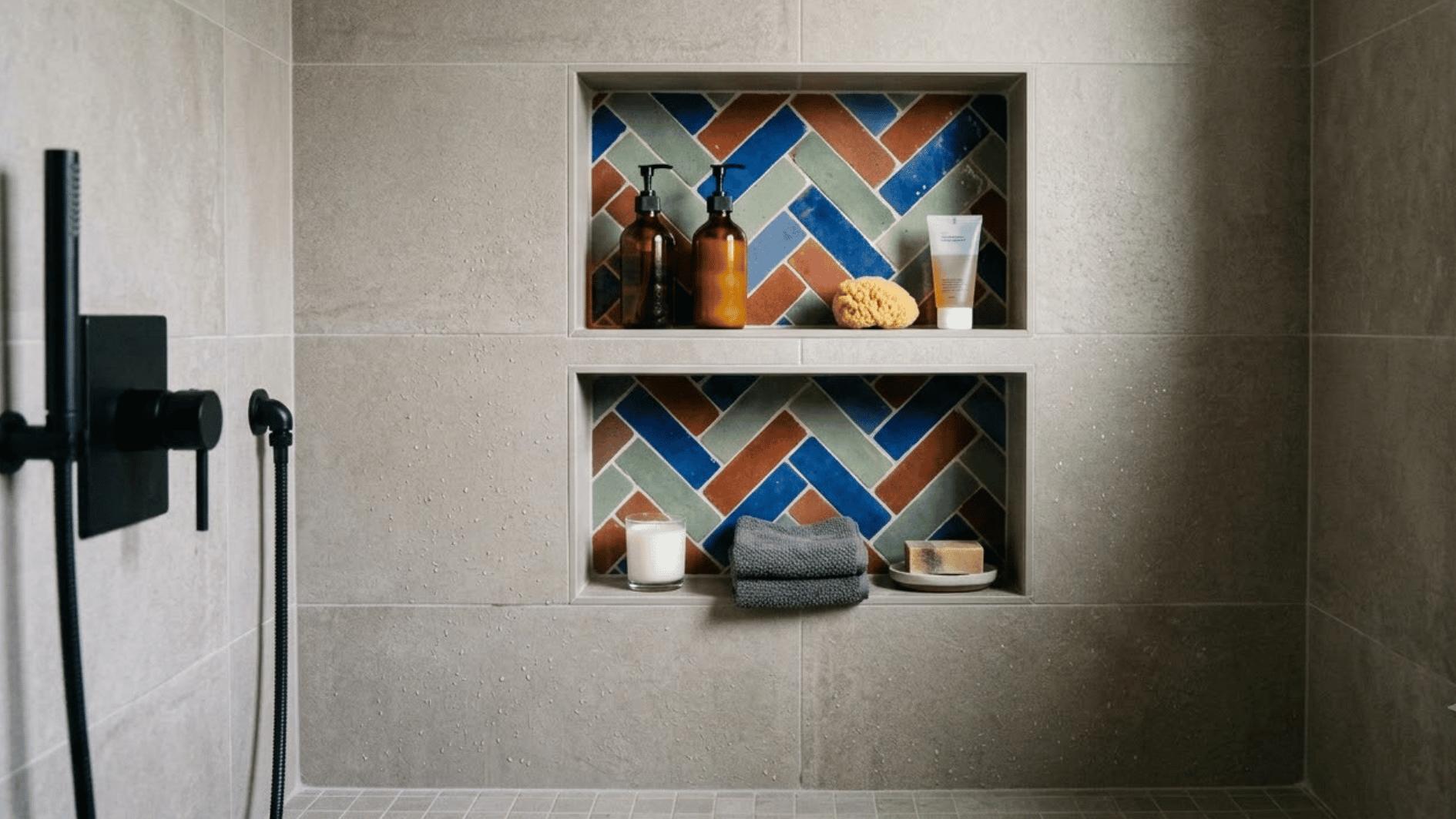 colorful ceramic tile shower niche with toiletries and candles inside a modern open shower wall
