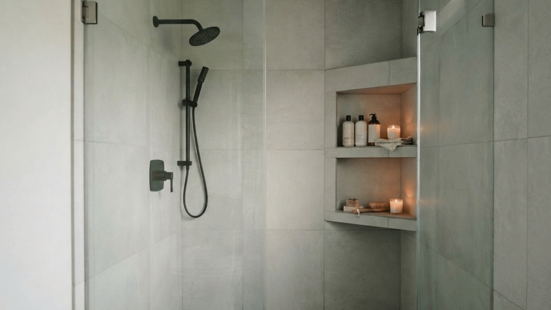 corner shower niche with toiletries and candles in a compact modern tiled shower enclosure