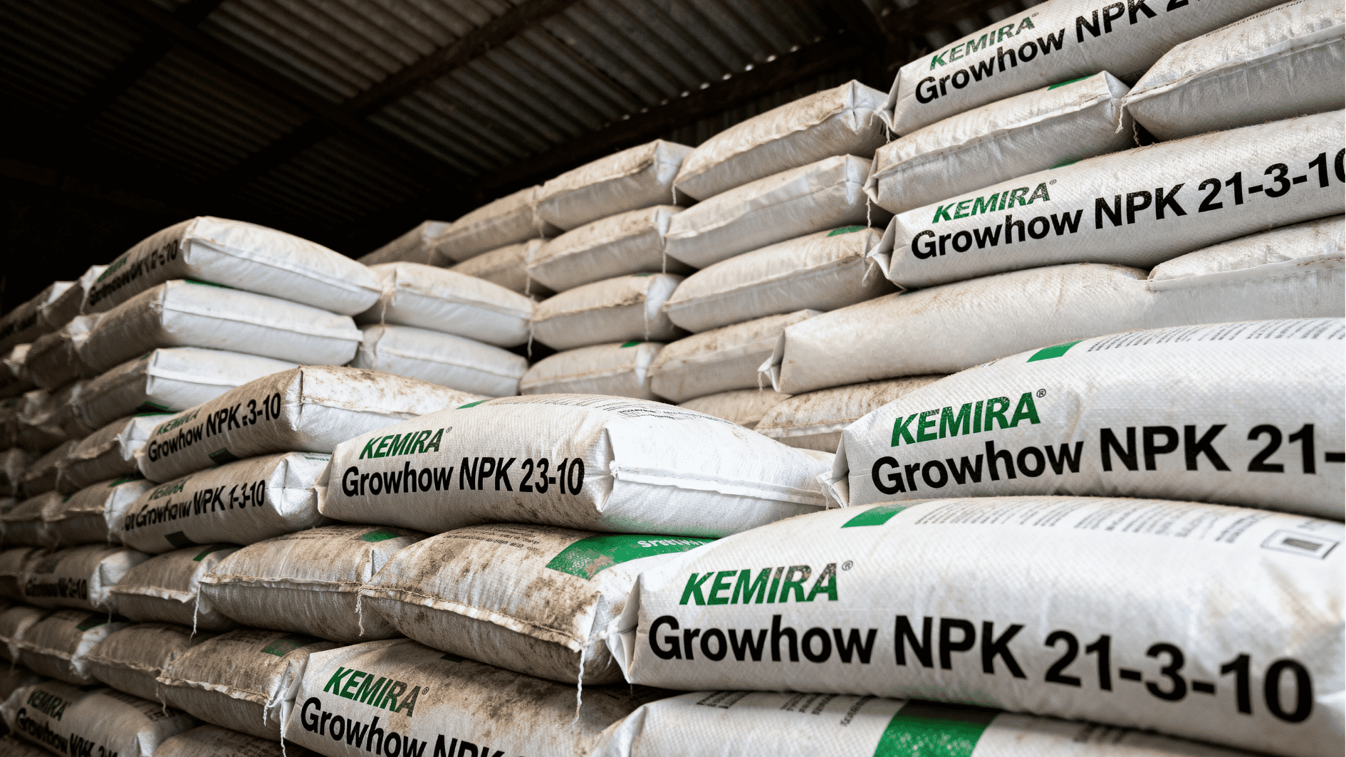 stacked bags of npk fertilizer in a warehouse storage area with rows of packaged agricultural products