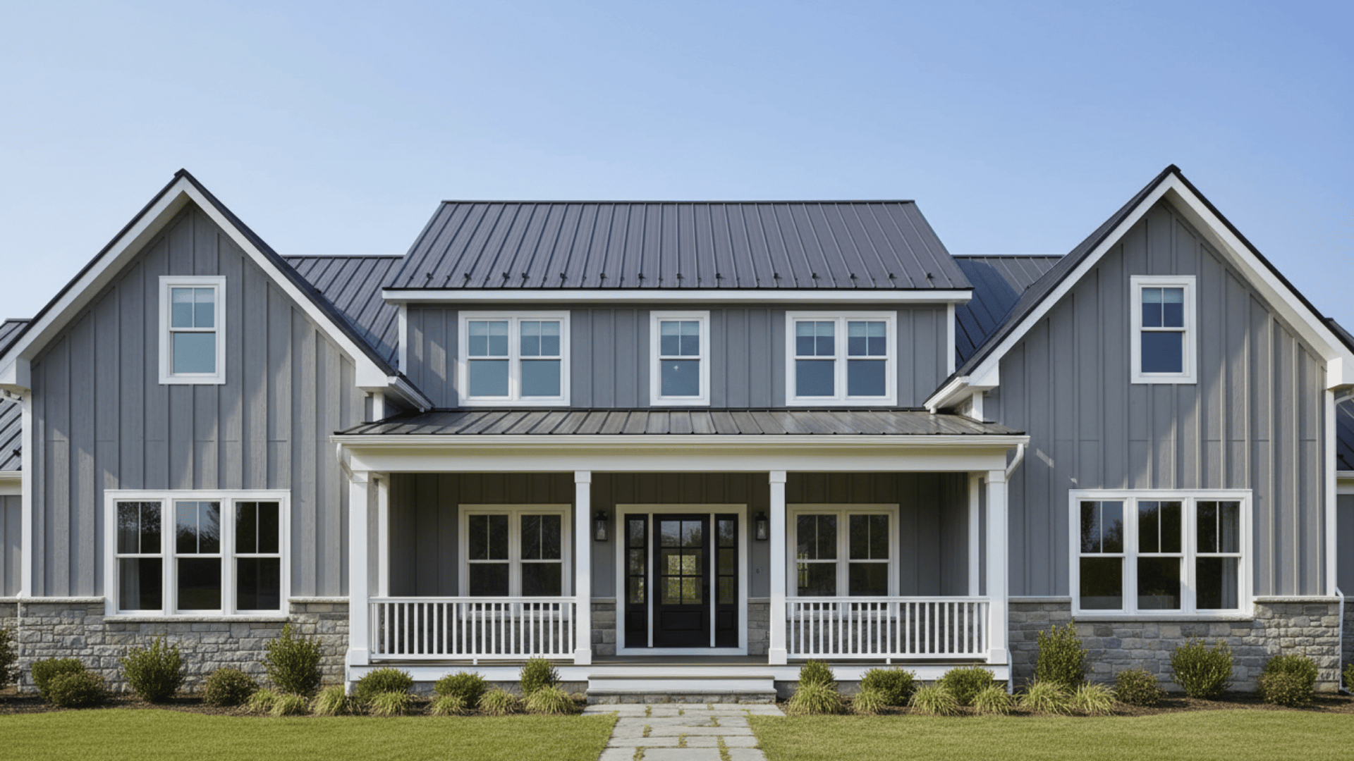 Gray board and batten house exterior with white trim, stone accents, and dark roof.