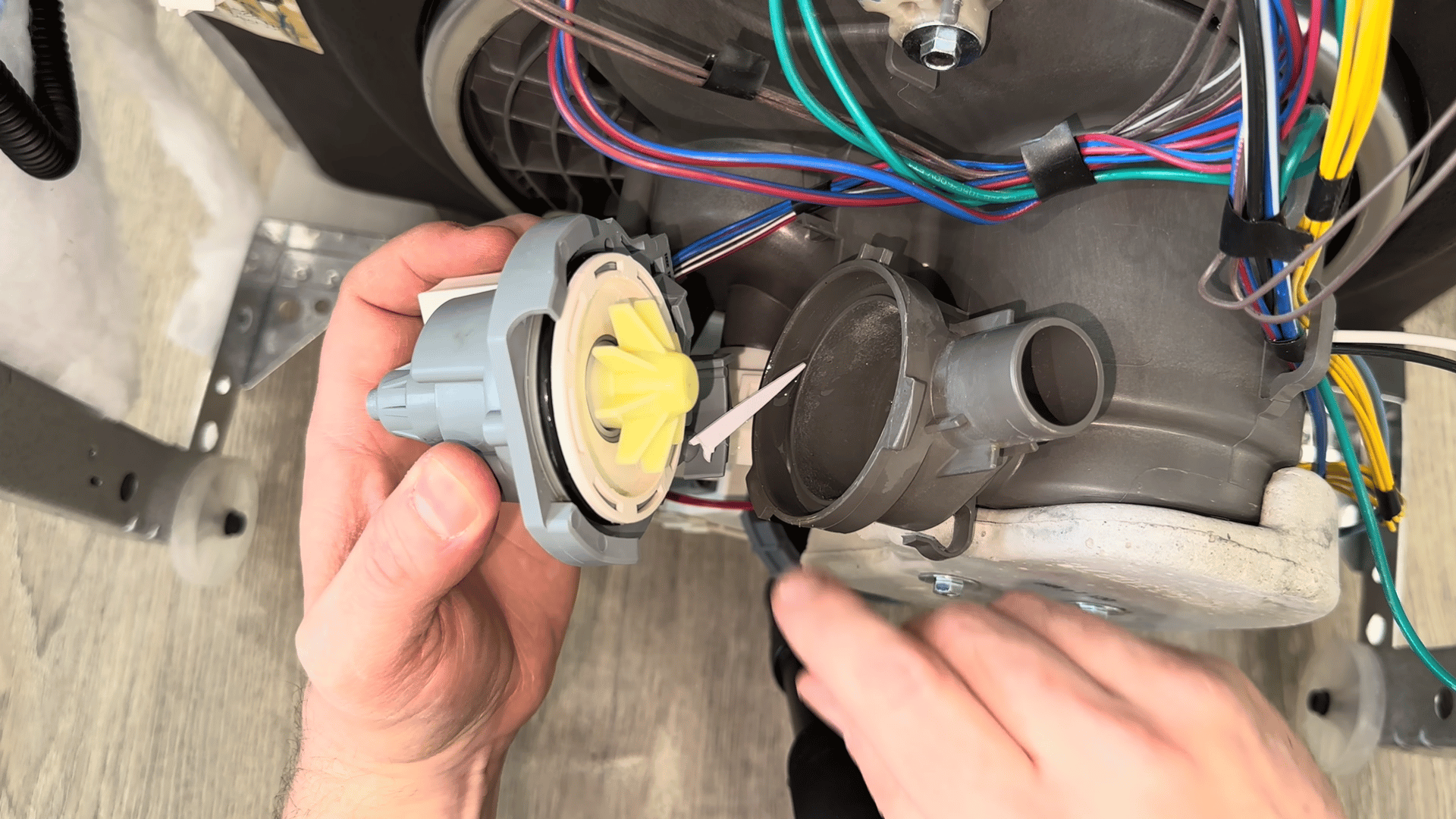 Inspecting the dishwasher drain pump for debris causing drainage problems