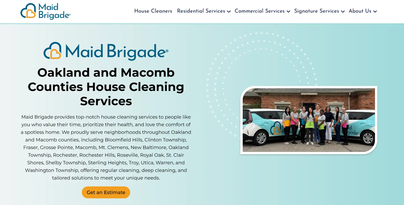 Cleaning team standing in front of branded vehicles outside brick building under overcast sky