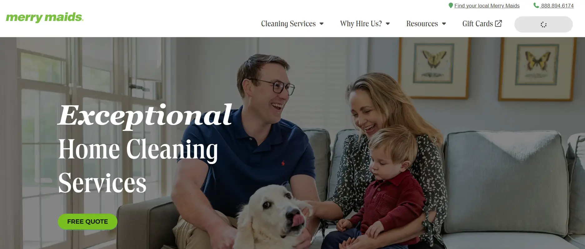 Family with young child and dog sitting on gray sofa in bright living room