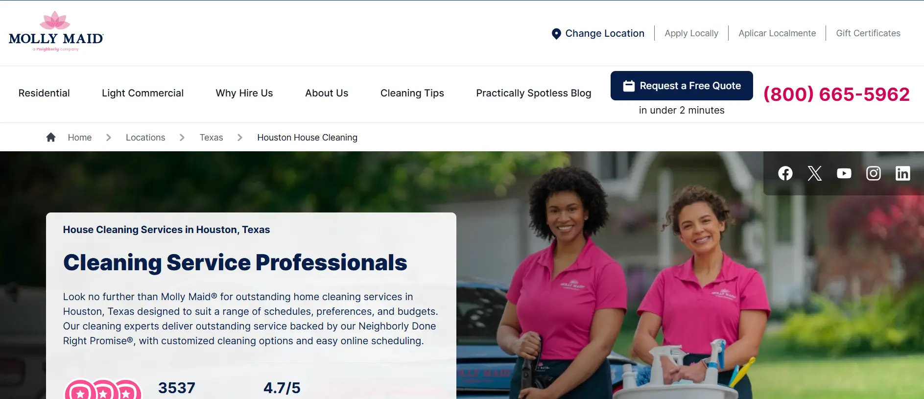 Two smiling women in pink uniforms holding cleaning supplies outdoors