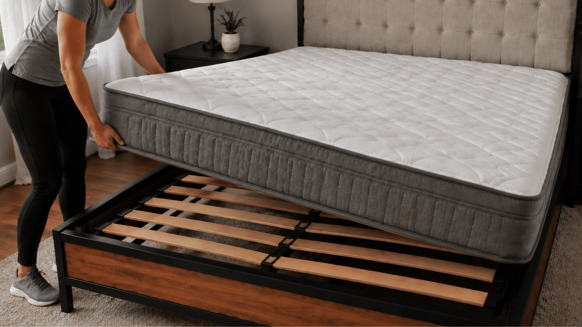 person lifting a mattress to clean the other side of the bed