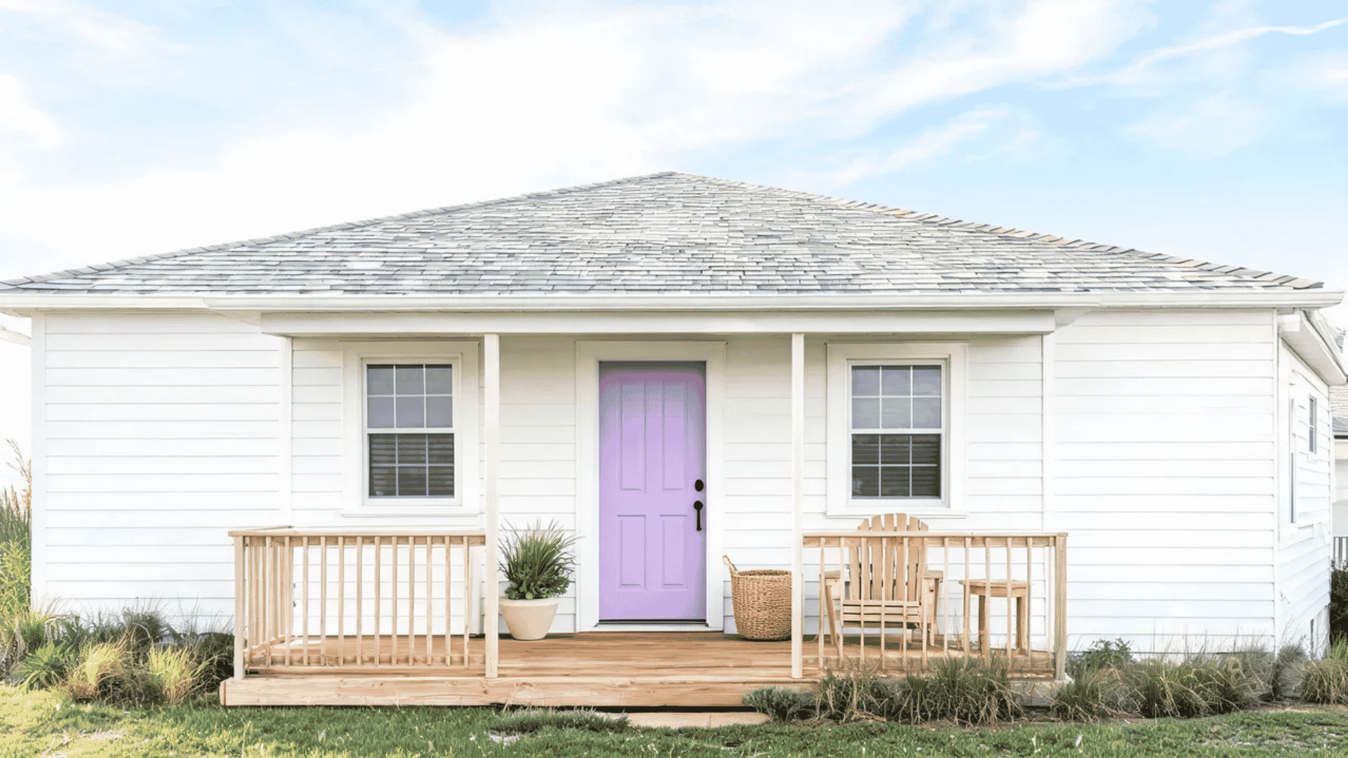 Purple front door in a coastal-style home with white walls, wood accents, and simple porch decor.