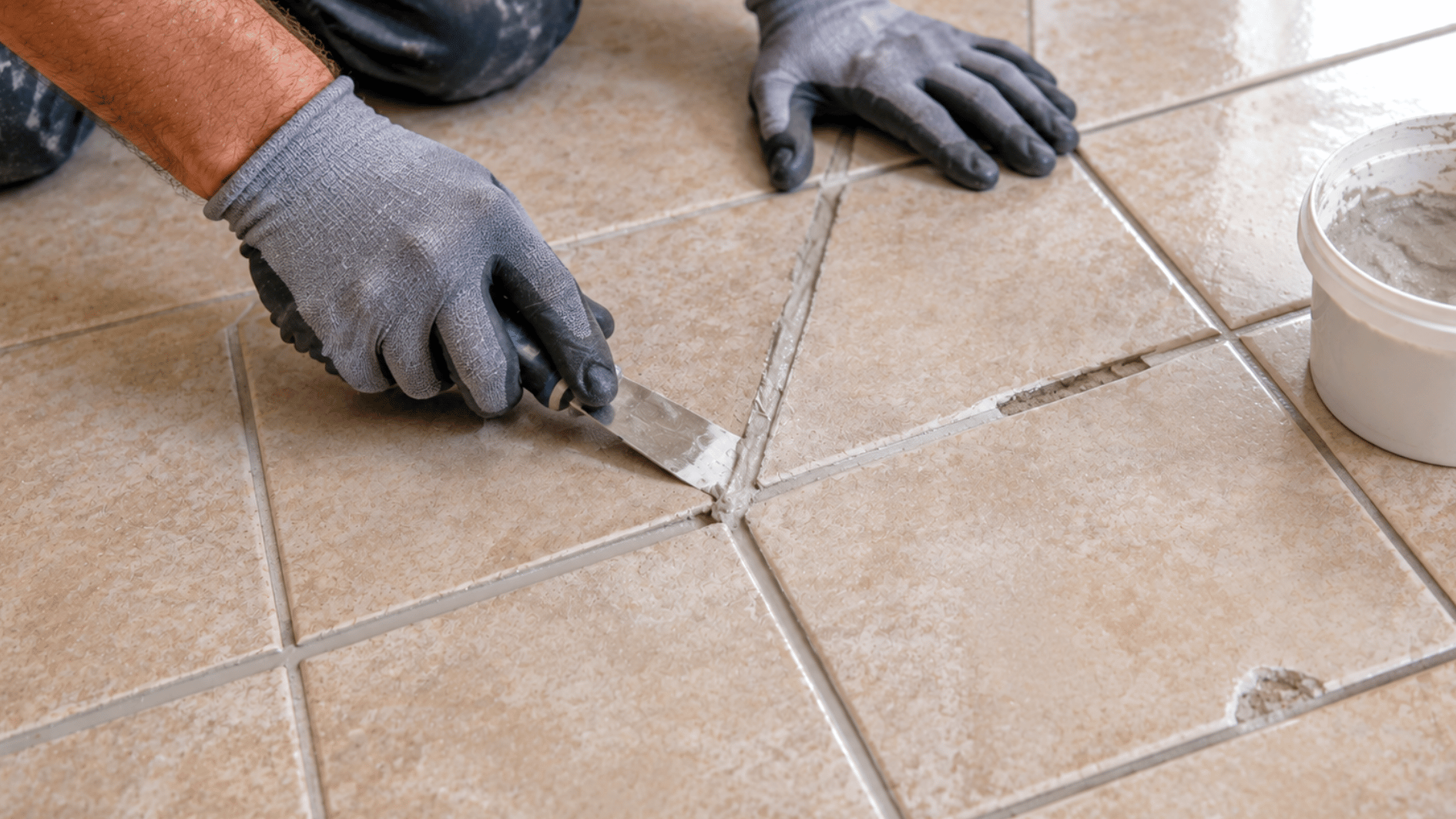 installer filling recessed grout joints and small surface gaps before laying new tile over existing tile