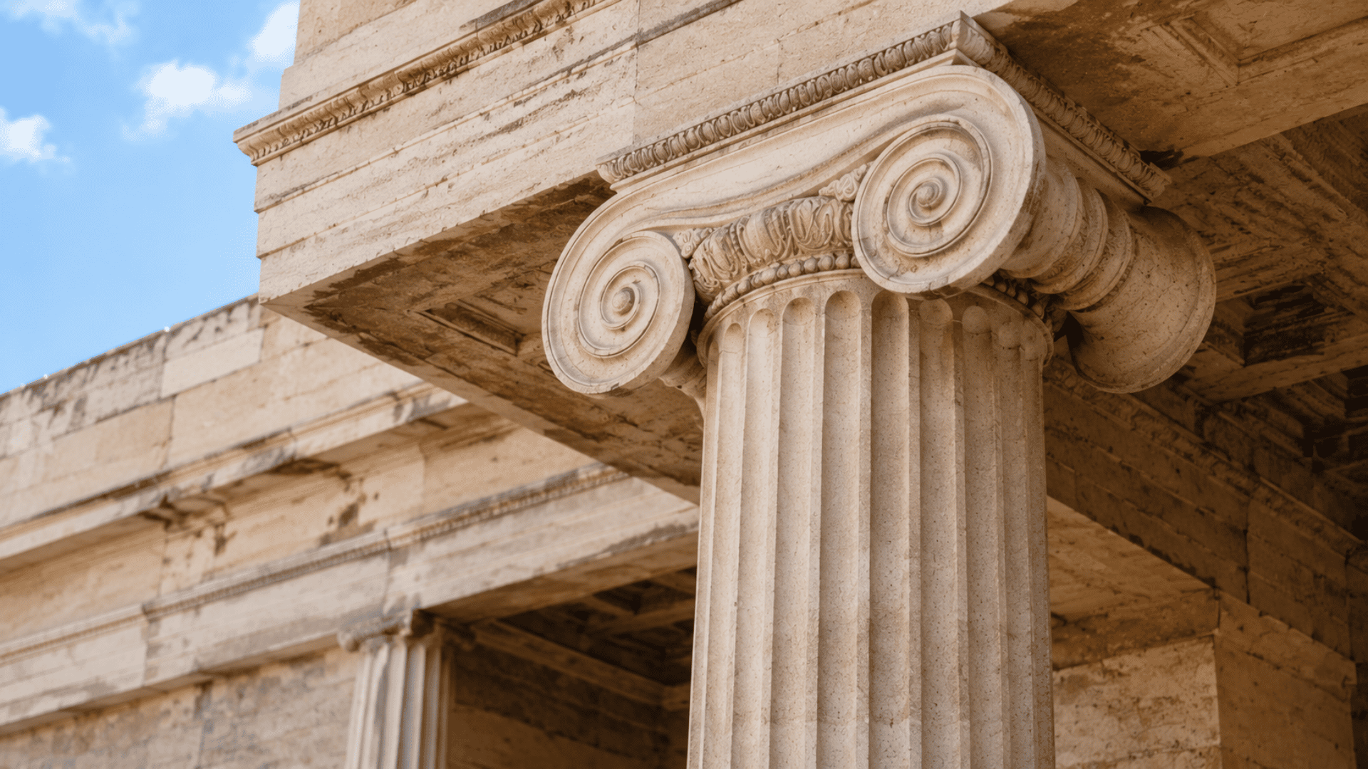 Slender Ionic column with scroll-shaped volute capital on a classical Greek building