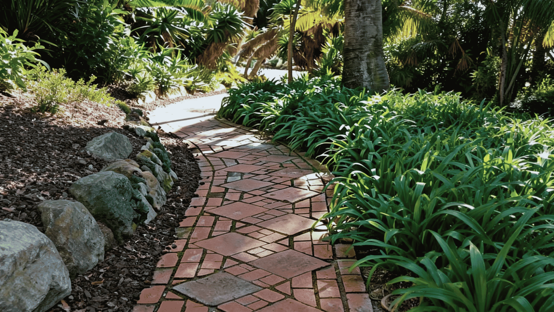 Stone and brick walkway combining different materials in a landscaped yard.