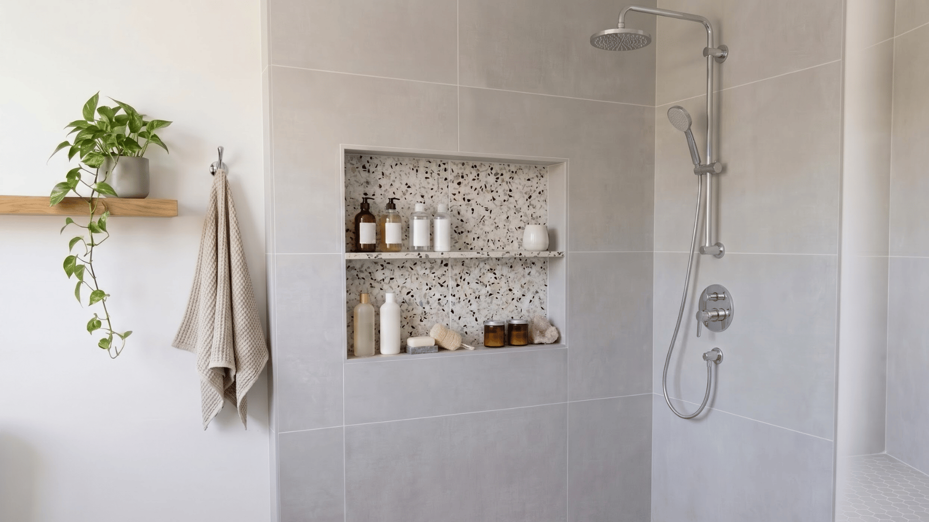 terrazzo tile shower niche with toiletries and candles inside a modern tiled shower wall