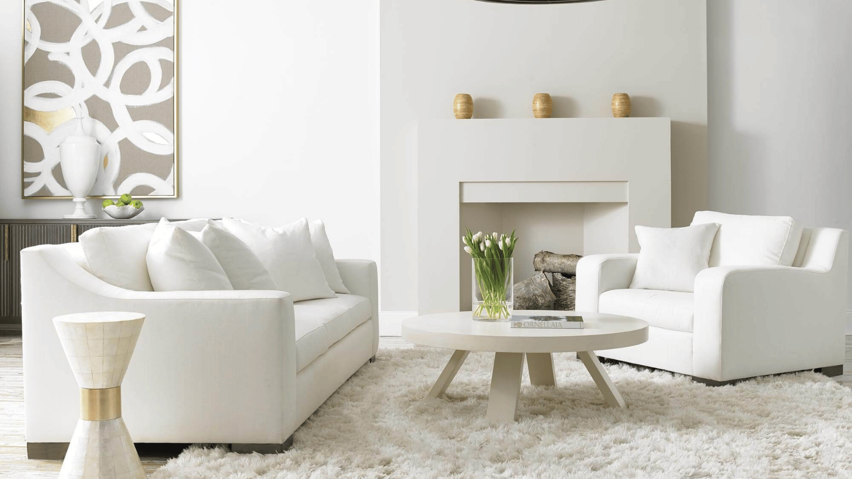 White living room with modern sofas, fireplace, round coffee table, and neutral minimalist decor.