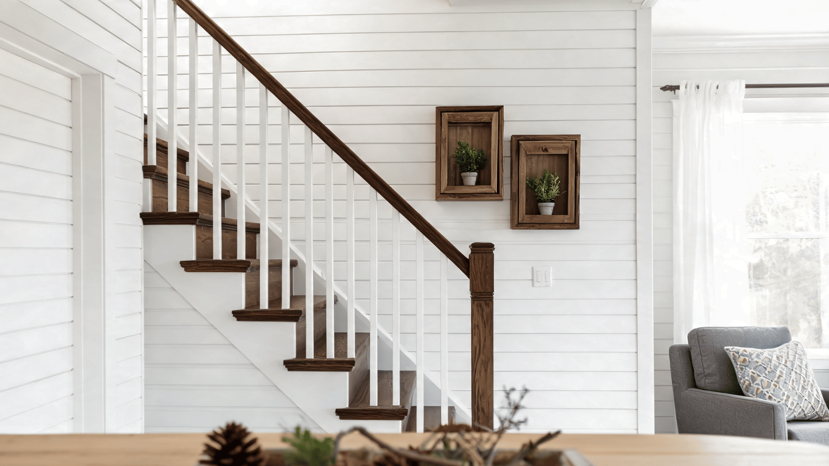 White shiplap staircase wall featuring wooden floating shadow box shelves and dark wood stairs.