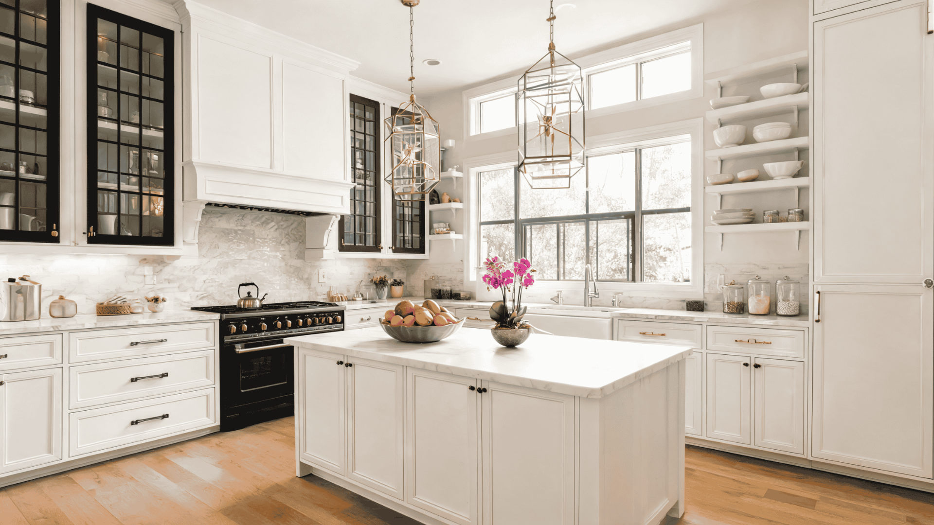 White transitional kitchen with paneled cabinets, marble island, mixed metal finishes, pendant lights, and wood flooring and modern kitchenware.