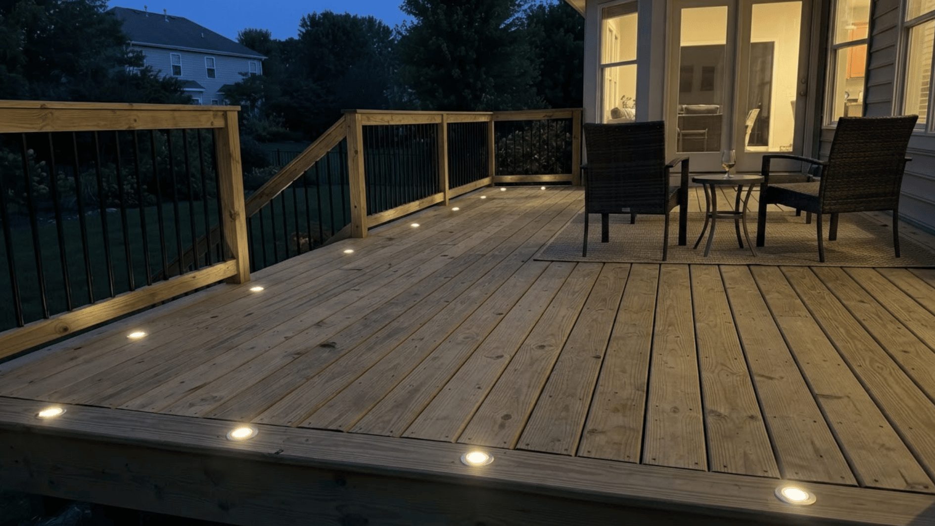 wooden deck with recessed floor lights glowing along walkways and seating areas at dusk (1)