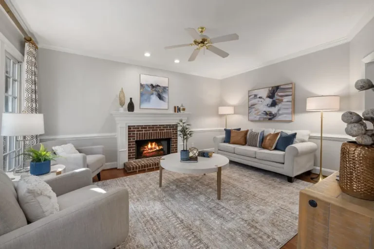 Cozy living room with lit fireplace, modern artwork, and neutral furniture under warm lighting