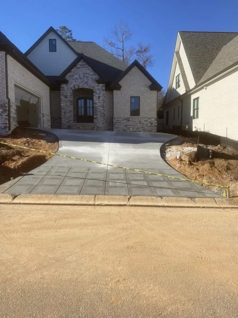Newly constructed stone house with steep driveway and protective tape in suburban neighborhood