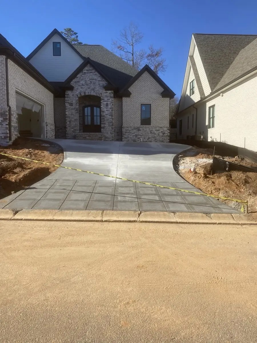 Newly constructed stone house with steep driveway and protective tape in suburban neighborhood