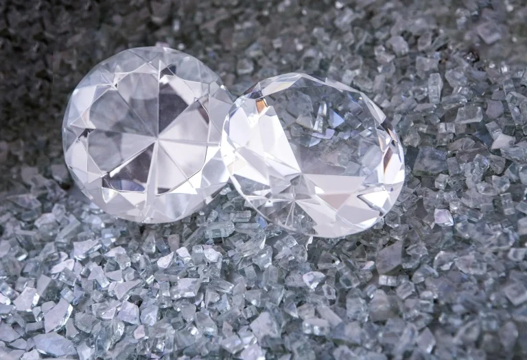 Two large clear diamonds resting on a bed of smaller crushed crystals