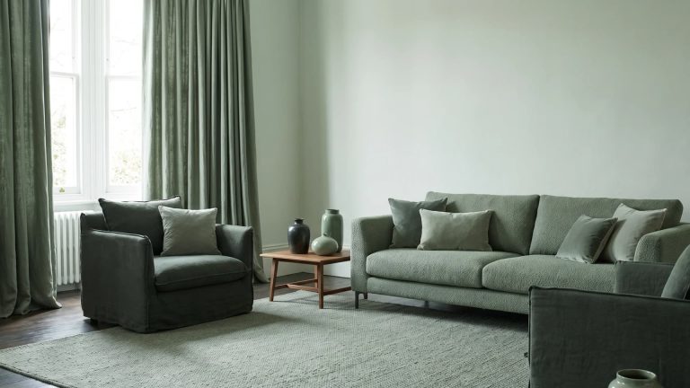 Monochromatic sage green living room with matching sofa, curtains, and rug.