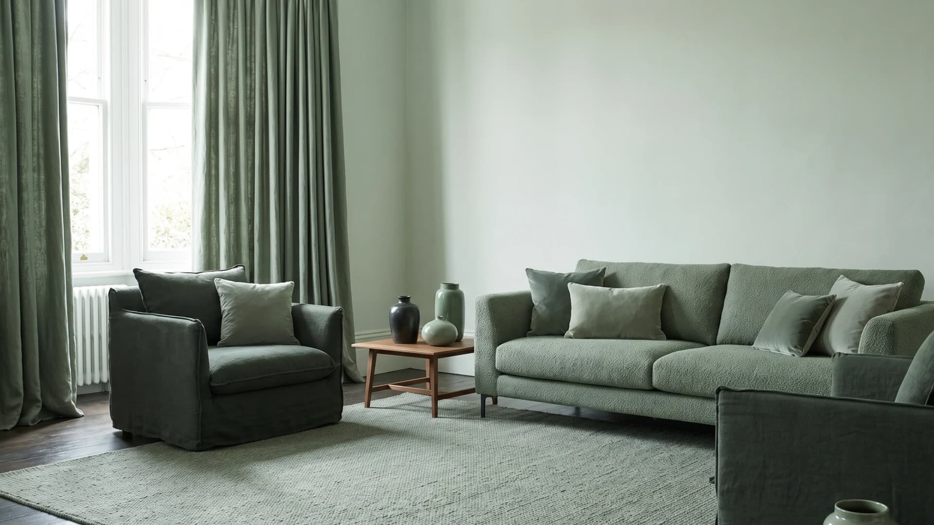 Monochromatic sage green living room with matching sofa, curtains, and rug.