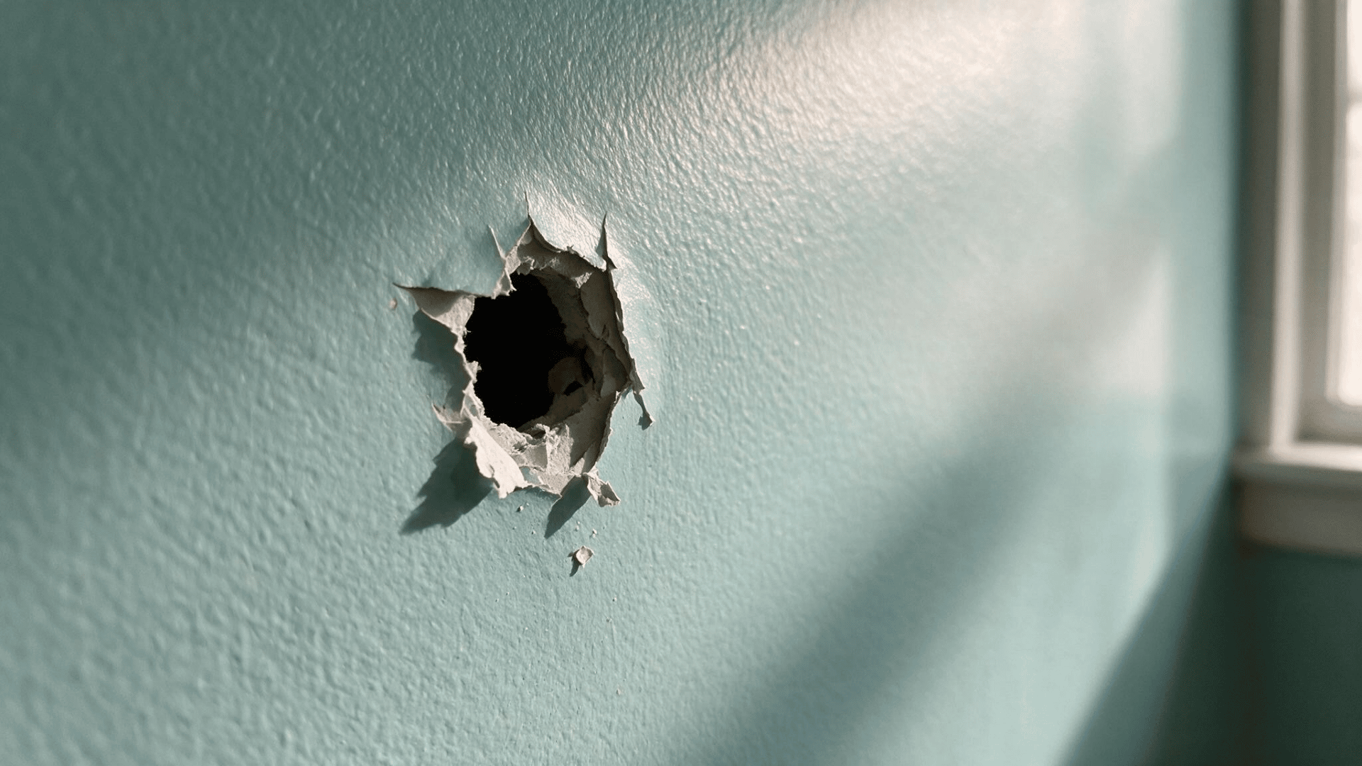 small holes in a light blue painted drywall wall