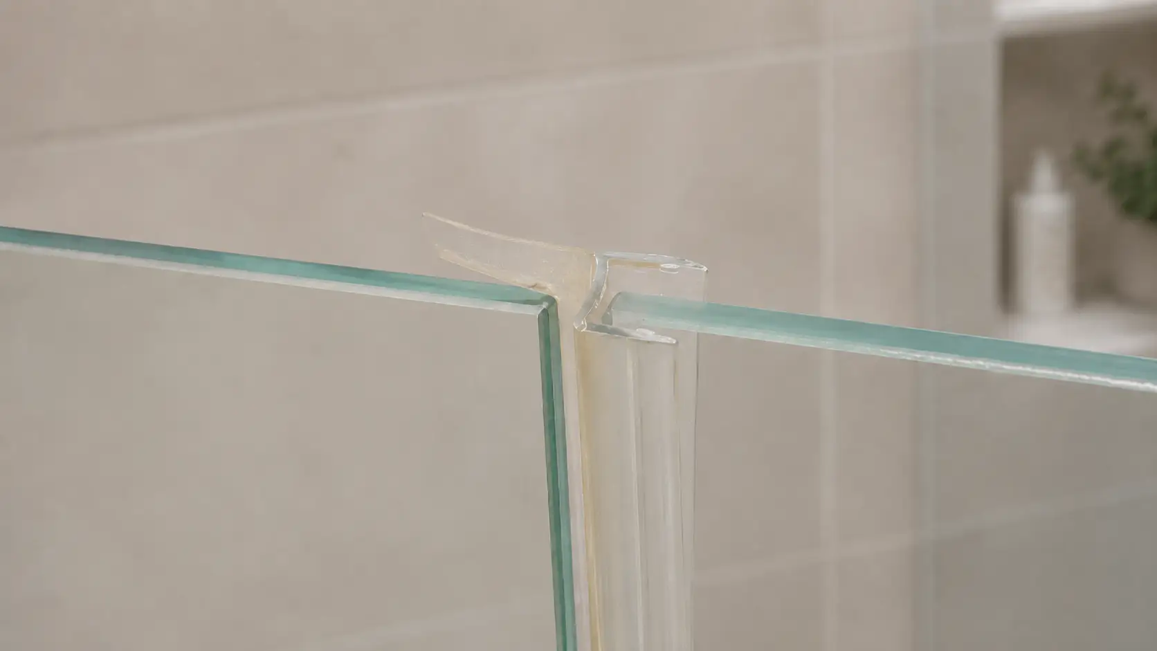 Glass corner joint with transparent sealant in modern bathroom setting