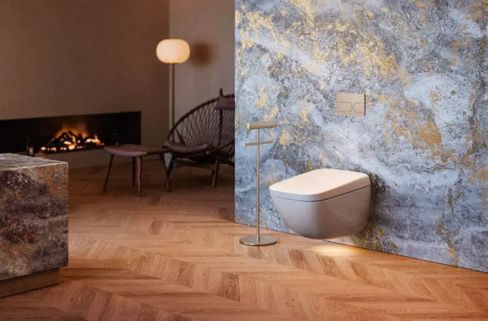 Modern bathroom with wall-mounted toilet and marble accent wall in warm lighting ambiance