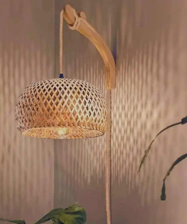 Woven bamboo pendant light casting patterns on a wall in a cozy room setting